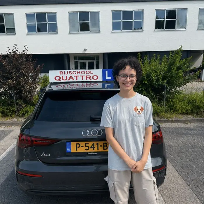 Geslaagde leerling van Rijschool Quattro bij de lesauto in Amersfoort